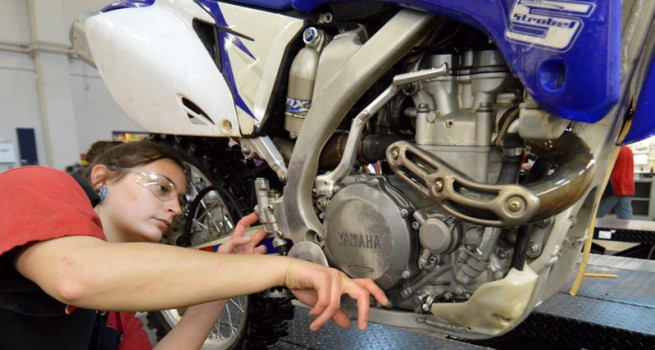 student working on motorcycle