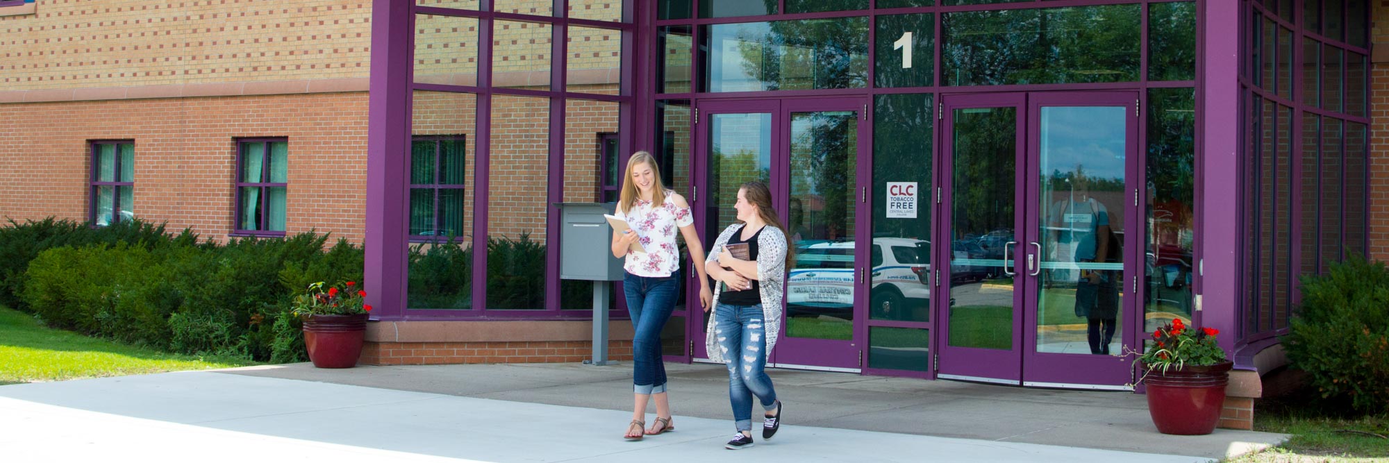 people walking out of campus building