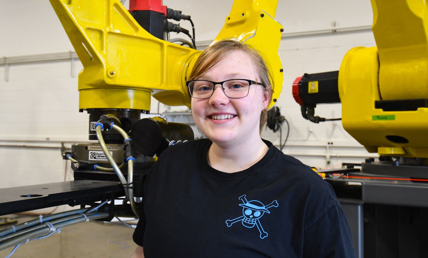 student standing by robotic machine