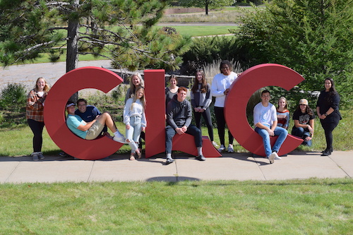 Big red letters and students on patio.